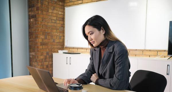 young asian woman reviewing results on a computer