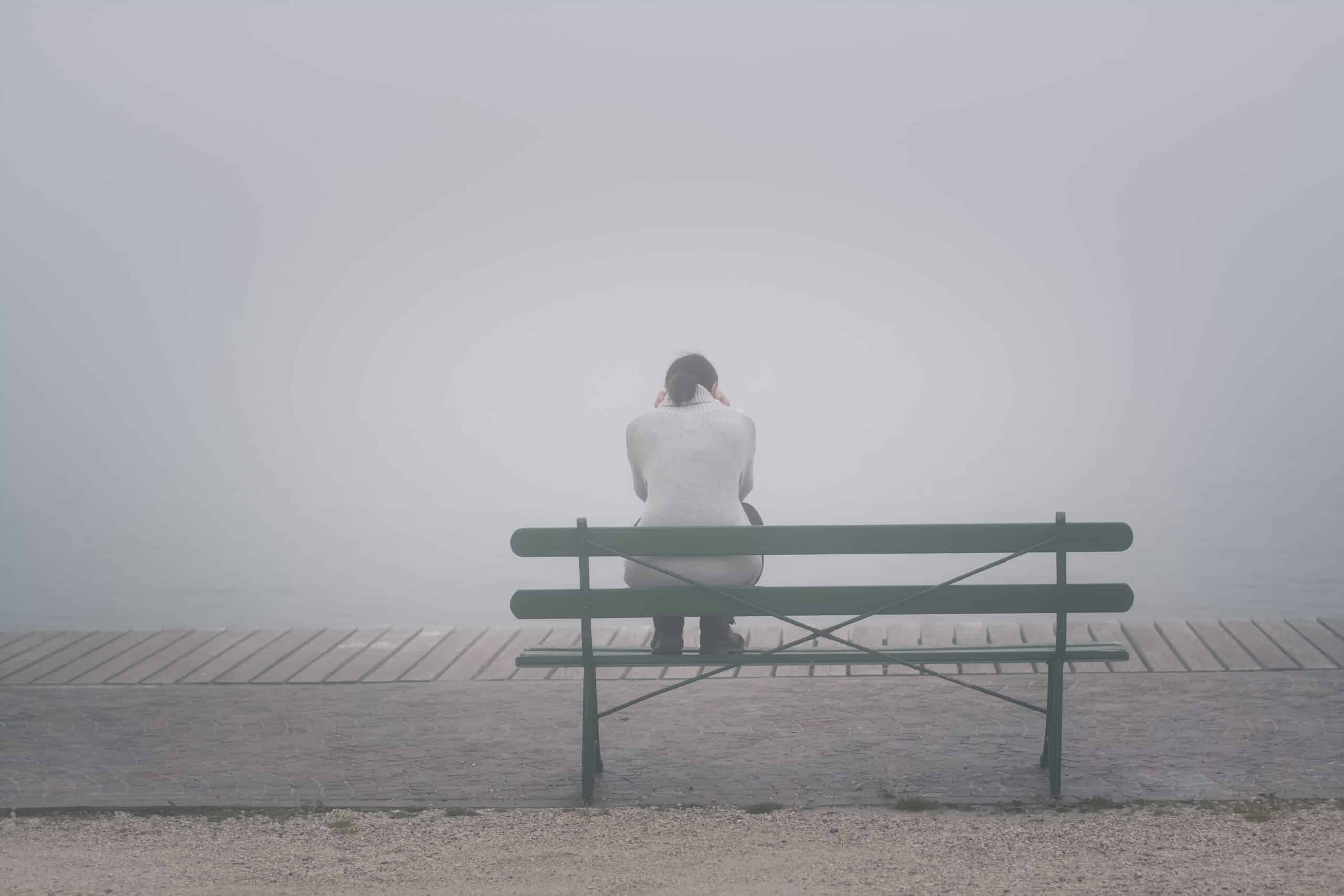 Employee who is on a bench on a foggy day, experiencing burnout and quiet quitting