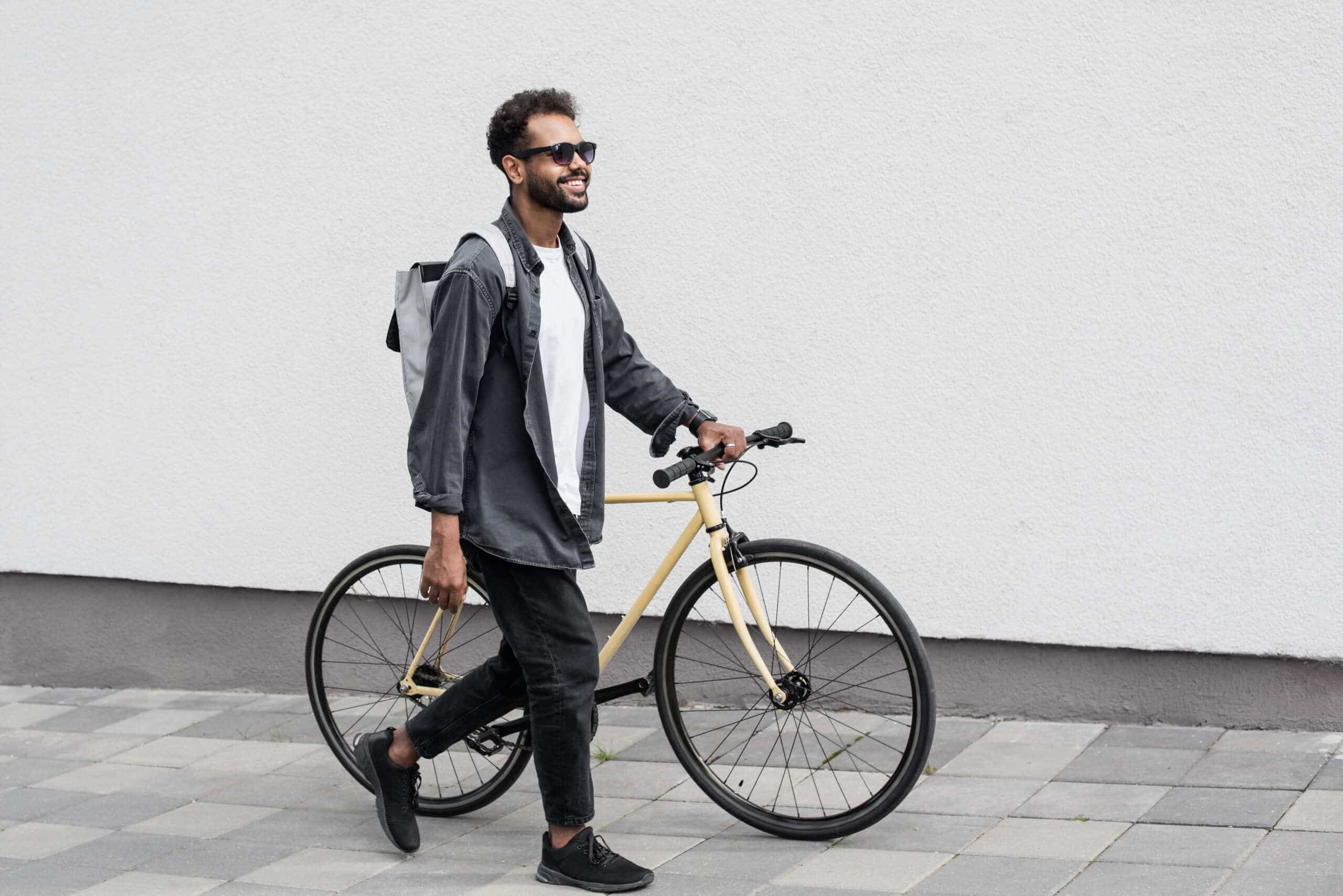 Handsome young man with bicycle in city,